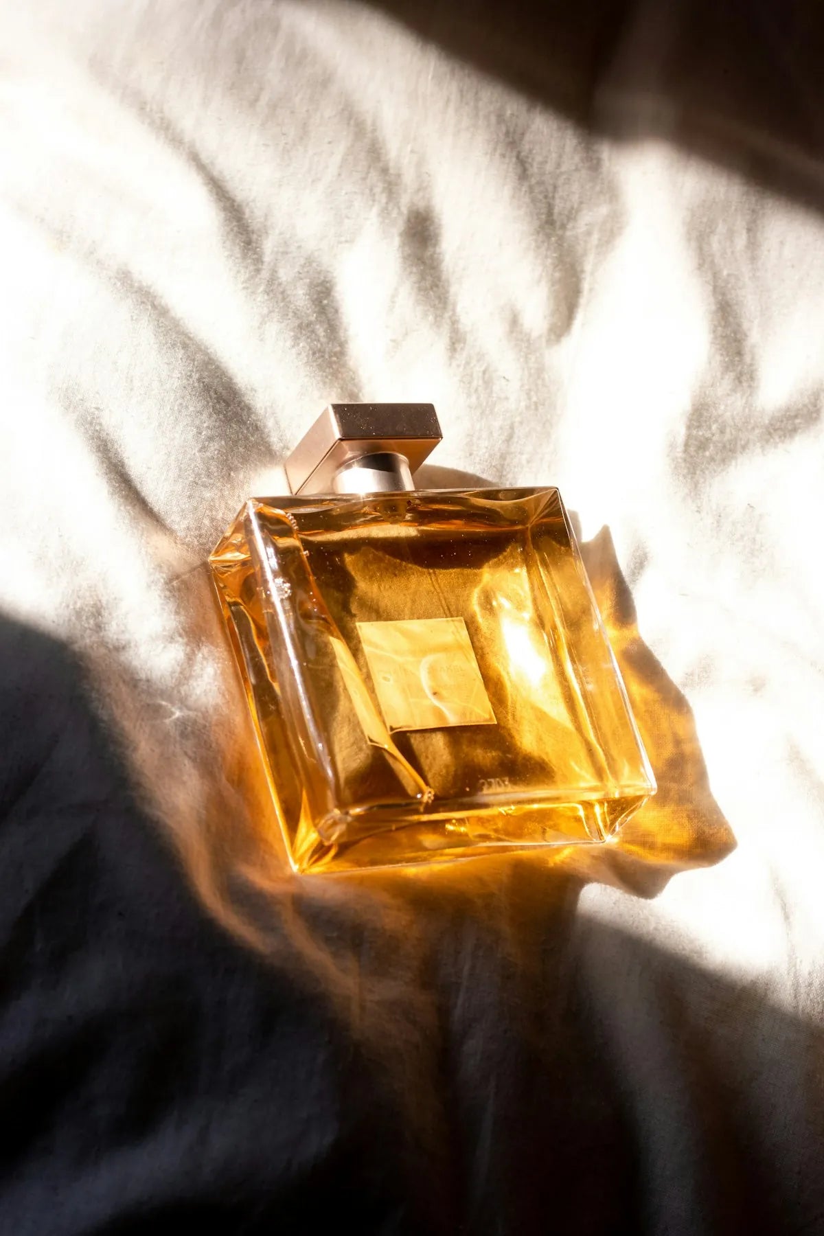 Khamrah, frasco de perfume ambar sobre tela calida